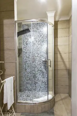 a shower with a glass door in a bathroom at The Royal Palm B&B in Ohrigstad