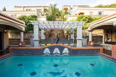 an outdoor swimming pool with a pergola and a swimming poolvisor at The Royal Palm B&B in Ohrigstad