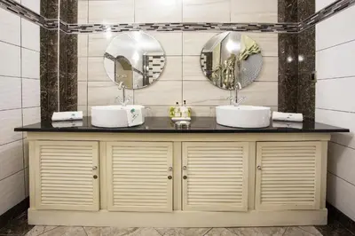 a bathroom with two sinks and two mirrors at The Royal Palm B&B in Ohrigstad