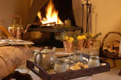 a fireplace with a tray of tea and cookies in front of it at Elonda B&B in Pretoria