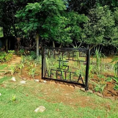 a gate with graffiti on it in a garden at Harties Is Africa Safari Lodge in Hartbeespoort