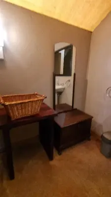 a bathroom with a table with a mirror and a sink at Harties Is Africa Safari Lodge in Hartbeespoort
