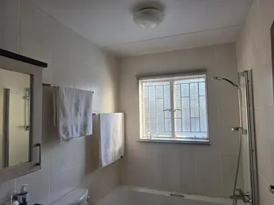 a bathroom with a tub and a toilet and a window at The Urban Dessert 