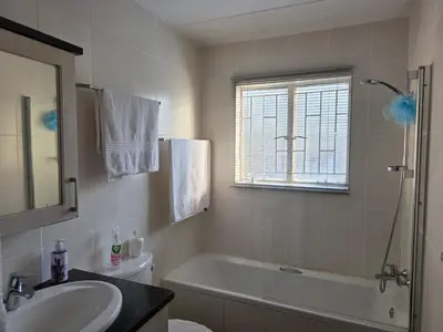 a bathroom with a bath tub and a sink and a mirror at The Urban Dessert 