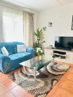 a living room with a blue couch and a glass coffee table at The Urban Dessert 