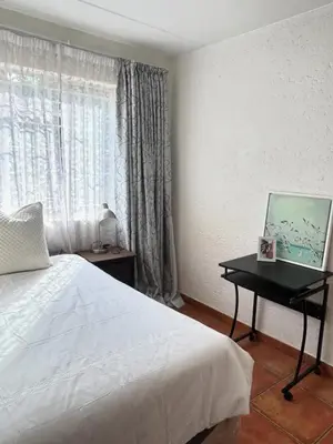 a bedroom with a bed and a desk and a window at The Urban Dessert 