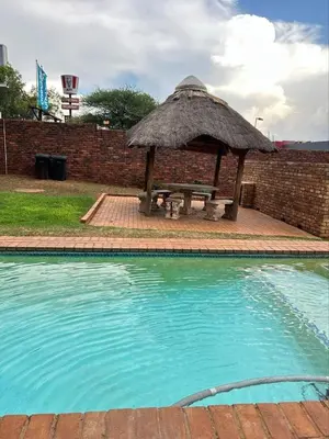 a picnic table with a grass umbrella next to a pool at The Urban Dessert 