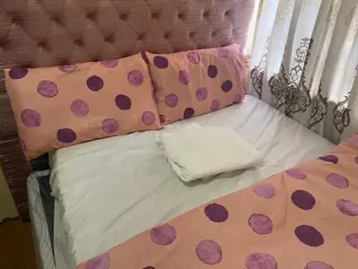 a bed with polka dots and pillows on it at Cardinal Guest House in Pretoria