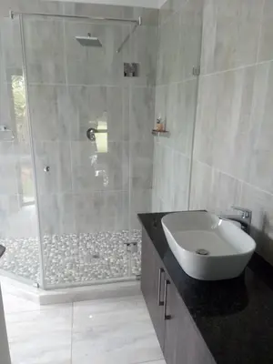 a bathroom with a shower and a sink and a tub at BudiasGuest B&B in Kempton Park