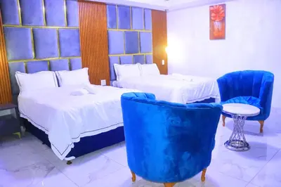 a hotel room with two beds and blue chairs at Musina Crown Guest House in Musina
