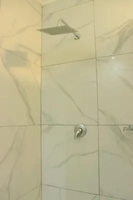 a shower with a glass door with a shower head at Musina Crown Guest House in Musina