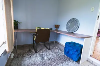a room with a desk with a mirror and a chair at House 22 on Alice in Centurion
