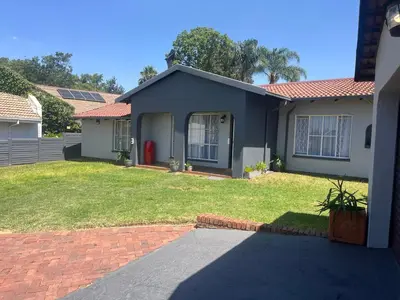 a blue house with a lawn in front of it at House 22 on Alice in Centurion