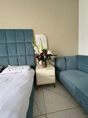 a bedroom with a couch and a table with a vase of flowers at Mphoentle residence in Midrand
