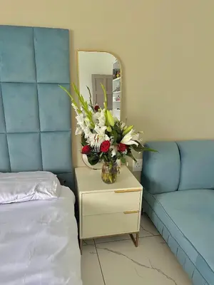 a vase of flowers on a table next to a bed at Mphoentle residence in Midrand