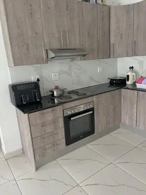 a kitchen with wooden cabinets and a stove top oven at Mphoentle residence in Midrand