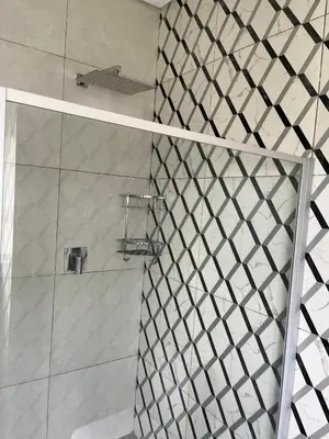 a bathroom with a shower with a glass door at Mphoentle residence in Midrand