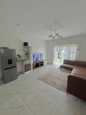 a white living room with a couch and a tv at Mphoentle residence in Midrand