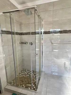 a shower with a glass door in a bathroom at The Ripanga Nest in Nelspruit