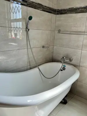 a white bath tub in a bathroom with a shower at The Ripanga Nest in Nelspruit