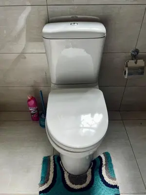 a white toilet in a bathroom with a rug at The Ripanga Nest in Nelspruit