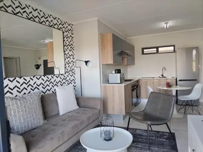 a living room with a couch and a kitchen at Greencreek Lifestyle in Pretoria