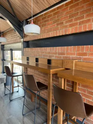 a brick wall in a room with a wooden table and chairs at Greencreek Lifestyle in Pretoria