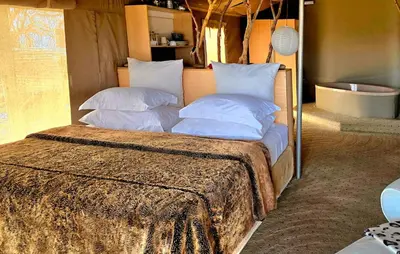 a bed with white pillows in a room at Thulani in Doornfontein