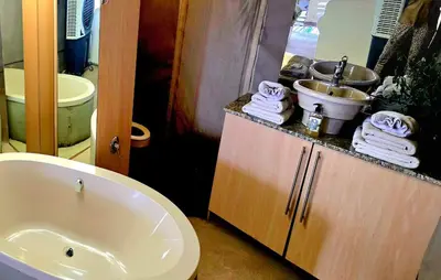 a bathroom with a tub and a sink and towels at Thulani in Doornfontein