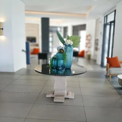 a table with a blue vase with flowers on it at The Blyde 1-Bed Luxe Apartment in Pretoria