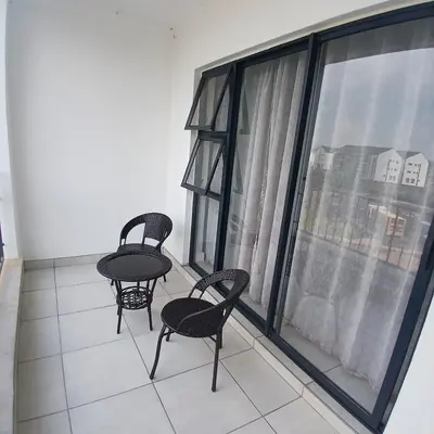 two chairs and a table on a balcony with a window at The Blyde 1-Bed Luxe Apartment in Pretoria