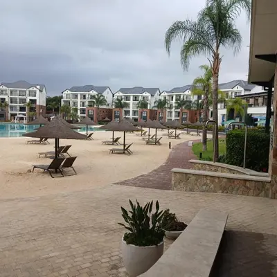 a resort with tables and umbrellas and a pool at The Blyde 1-Bed Luxe Apartment in Pretoria