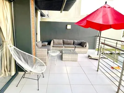 a living room with a couch and a red umbrella at Lake Villa Hartebees in Hartbeespoort