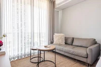 a living room with a couch and a table at Cozy Stay at The Ellipse Waterfall in Midrand