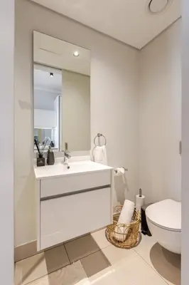 a white bathroom with a sink and a toilet at Cozy Stay at The Ellipse Waterfall in Midrand
