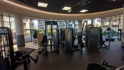 a gym with a bunch of treadmills and machines at Cozy Stay at The Ellipse Waterfall in Midrand
