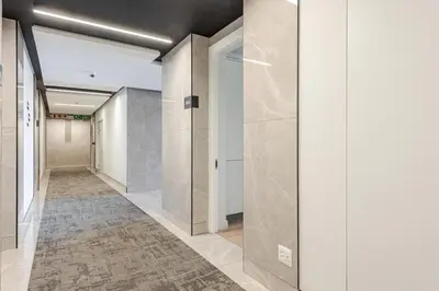 a hallway with white and beige walls and doors at Cozy Stay at The Ellipse Waterfall in Midrand