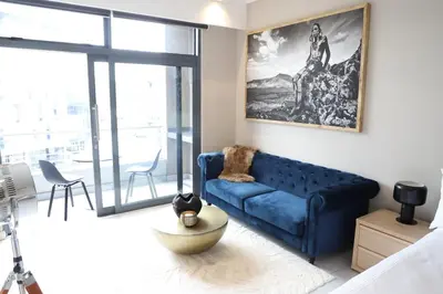 a living room with a blue couch and a large window at 418 menlyn Maine trilogy in Pretoria