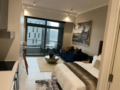 a bedroom with a bed and a living room at 418 menlyn Maine trilogy in Pretoria