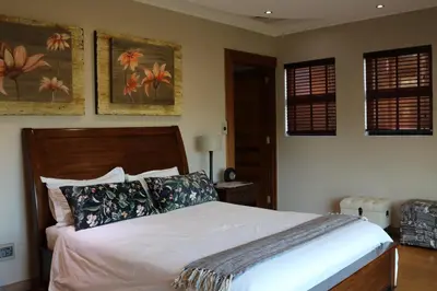 a bedroom with a bed and two pictures on the wall at Highland Gate Golf & Trout Estate, House 925 in Dullstroom