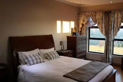 a bedroom with a large bed and a window at Highland Gate Golf & Trout Estate, House 925 in Dullstroom