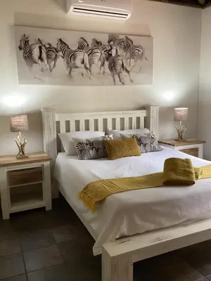 a bedroom with a white bed with drawings of zebras at Sounds of Kruger Safari Villa in Marloth Park