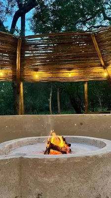 a fire in a fire pit with lights in it at Sounds of Kruger Safari Villa in Marloth Park