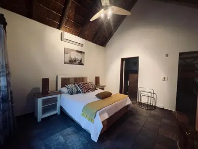 a bedroom with a bed with a nightstand and a bed sidx sidx sidx sidx at Sounds of Kruger Safari Villa in Marloth Park
