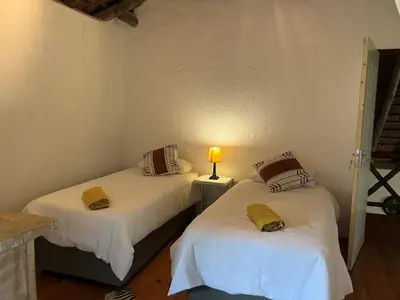 two beds in a room with a lamp on a table at Sounds of Kruger Safari Villa in Marloth Park