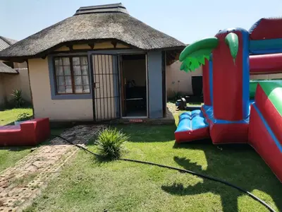 a small house with a slide in the yard at Jamrock Lodge in Winterveld