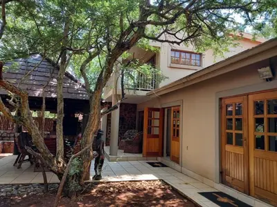 a house with a tree in front of it at Warthog Corner in Leeupoort