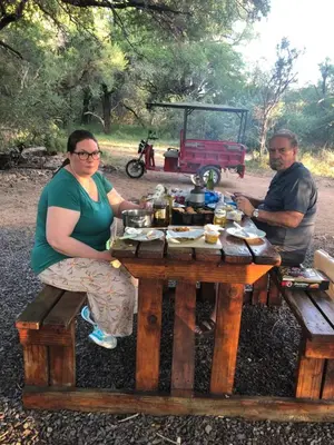 a man and a woman sitting at a picnic table at Warthog Corner in Leeupoort