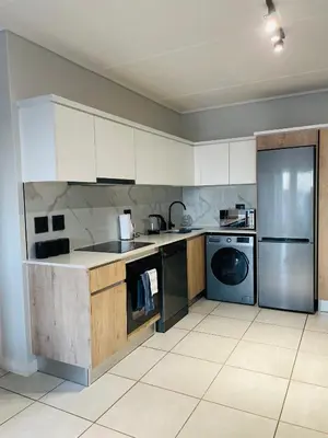 a kitchen with white cabinets and stainless steel appliances at 2 Bedroom- The Blyde by Given in Pretoria