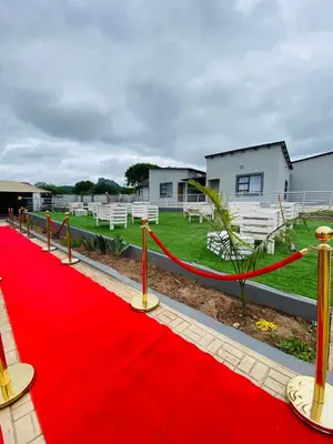 a red carpet on a field with white chairs at Shibar farm house Mpumalanga in eLundi